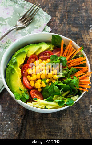 Bol bouddha vegan avec quinoa, avocat, carottes, maïs, tomates et courgettes - Vue de dessus Banque D'Images