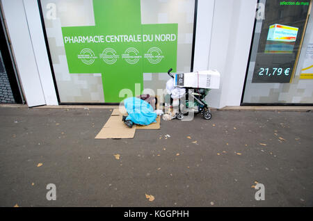 Paris, France. Personne sans-abri dorment dans la rue en dehors d'une pharmacie à proximité de la Gare du Nord Banque D'Images
