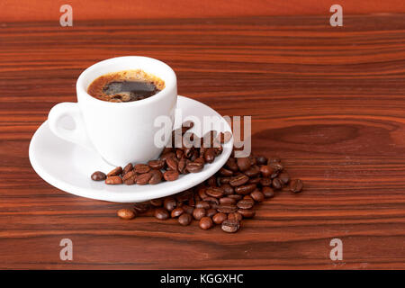 Tasse de café avec les grains de café sur fond de bois Banque D'Images