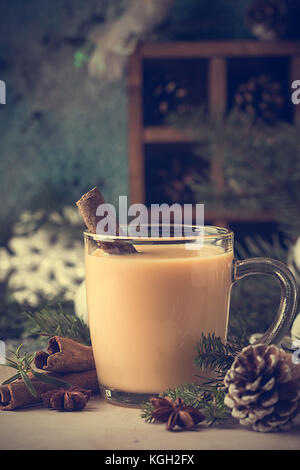 D'hiver traditionnel de poule dans une tasse en verre avec le lait, le rhum et la cannelle, les décorations de Noël Banque D'Images