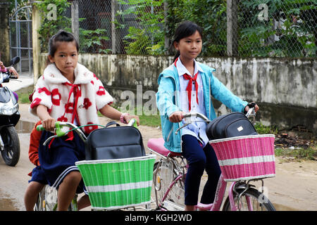 Binh Dinh, le Viet nam- nov 3, 2017:groupe d'enfants vietnamiens en rentrant de l'école en vélo, petite fille asiatique foule cycle ride on country road, Banque D'Images