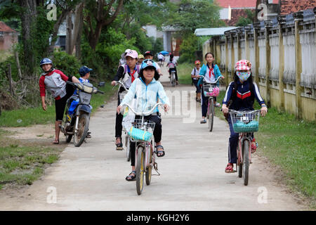 Binh Dinh, le Viet nam- nov 3, 2017:groupe d'enfants d'Asie en rentrant de l'école en vélo, faire du vélo élève vietnamien foule on country road, Vietnam Banque D'Images