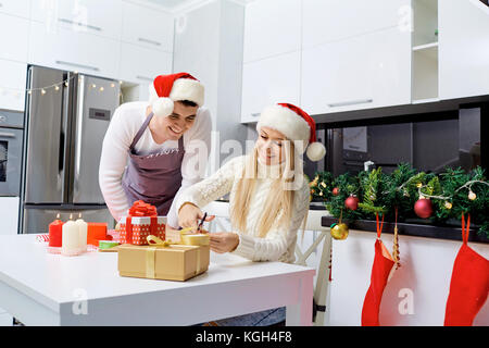 Un couple à Santa's caps rétractable présente dans un prix sur christma Banque D'Images
