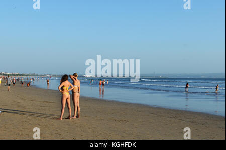 Young Caucasian women standing et de bronzage sur la plage de Kuta, Bali. Banque D'Images