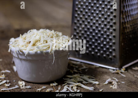 Racine de persil racine sur la grille et le persil. râpe sur la vieille table de cuisine dans la cuisine. fond noir Banque D'Images