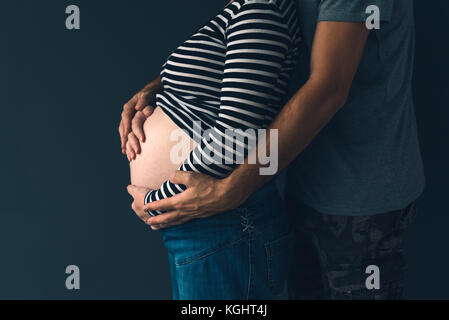 Soldier hugging sa femme enceinte, couple expecting baby, clé faible Banque D'Images