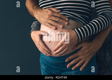 Soldier hugging sa femme enceinte, couple expecting baby, clé faible Banque D'Images