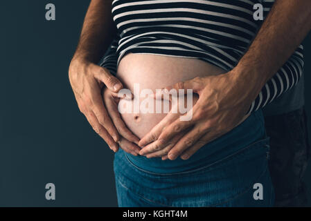 Soldier hugging sa femme enceinte, couple expecting baby, clé faible Banque D'Images