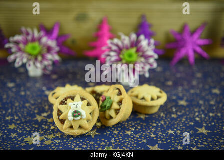 Noël Nourriture photographie image de petits pâtés traditionnels anglais avec mignon décoration glacé de l'ours polaire et le scintillement des décorations de l'arbre et de fleurs Banque D'Images