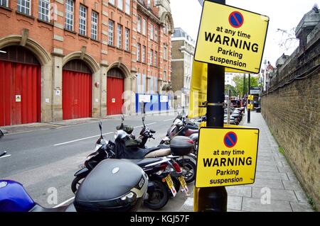 Ligne de motos en face de suspension parking signes sur Londres rue derrière la gare de Paddington, Londres, UK Banque D'Images