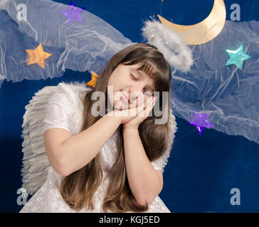 Girl in costume dort sur un fond de ciel bleu foncé avec motif étoile Banque D'Images