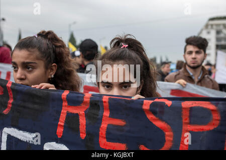 Athènes, Grèce. 08 novembre 2017. Des filles tiennent une banderole alors que les réfugiés marchent vers l'ambassade d'Allemagne pour protester contre les retards dans la réunification avec leurs proches en Allemagne à Athènes, en Grèce, le 8 novembre 2017. Le 1er novembre 2017, des réfugiés - principalement de Syrie - se sont rassemblés sur la place Syntagma dans le centre d'Athènes, en face du Parlement grec, entamant un siège de protestation et une grève de la faim pour demander aux gouvernements grec et allemand de respecter la limite légale de six mois pour les regroupements familiaux et d'être autorisés à rejoindre leurs familles en Allemagne. Crédit : dpa Picture alliance/Alamy Live Banque D'Images