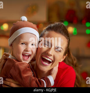 Portrait of smiling mother and baby in christmas cuisine décoration Banque D'Images