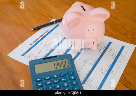 Demande de prêt hypothécaire sur 24 avec tirelire, calculatrice et stylo Banque D'Images