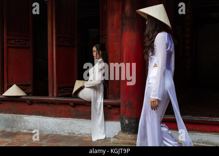Les jeunes femmes vietnamiennes portant l'habit traditionnel Ao Dai et le chapeau conique... Non Emplacement ; Temple de la littérature à Hanoi, Vietnam Banque D'Images
