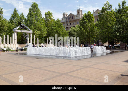 Les touristes jouant sur n fontaine interactive devant le monument aux victimes des nazis hongrois à Budapest en Hongrie. Banque D'Images