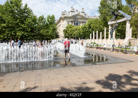 Square à Budapest avec l'homme marchant à travers la fontaine. Monument aux victimes des nazis hongrois. Banque D'Images