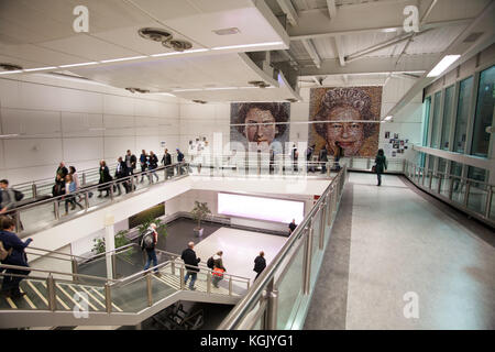 Les passagers à l'aéroport de Gatwick à pied par 'la monarch' : deux grands portraits de la reine, composé d'environ 5 500 photos de résidents britanniques. Banque D'Images