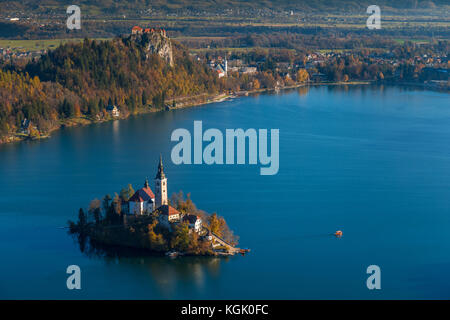 Bled, Slovénie - lever du soleil au lac Bled pris du point de vue d'Osojnica avec bateau traditionnel de Pletna et château de Bled en arrière-plan à l'automne Banque D'Images