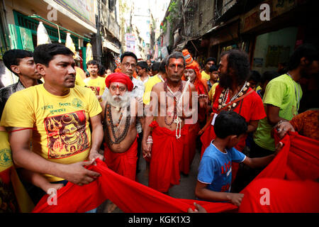 Hindous bangladeshis donnent de l'argent qu'ils prennent part à une activité rituelle appelée charak puja à Dhaka, au Bangladesh. Banque D'Images