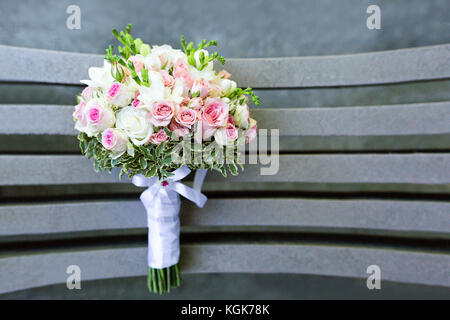 Bouquet de mariage rose et blanc vue de dessus. petites roses et fleurs blanches, placés sur un banc, pris à l'extérieur, de jour, de photo en gros plan. Banque D'Images