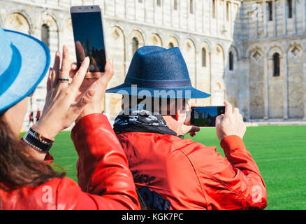 Les touristes asiatiques prendre des photos de la tour de Pise à l'aide de leurs smartphones, Pise, toscane, italie Banque D'Images