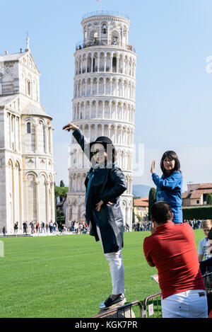 Les touristes asiatiques prennent des photos de la Tour penchée de Pise avec les bras levés à l'aide de leurs smartphones, Pise, Toscane, Italie Banque D'Images
