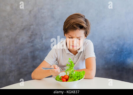 Cute teen boy n'aimez eating salad Banque D'Images