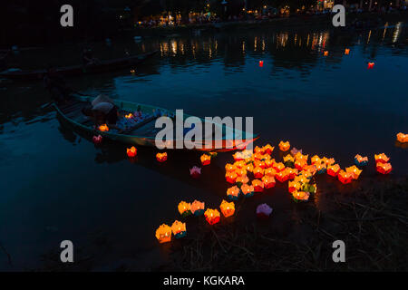 Une famille lancement bougies flottantes sur la rivière Thu Bon dans l'ancienne ville de Hoi An, au Vietnam. Une vieille tradition. Banque D'Images