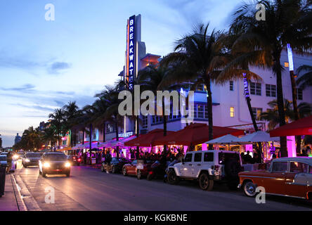 Les voitures et la circulation dans la soirée sur Ocean Drive, en face de Breakwater hotel et immeubles Art déco de South Beach, Miami, Floride, USA. Banque D'Images