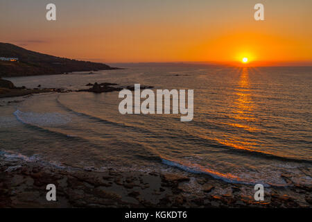 Magnifique coucher de soleil sur une plage rocheuse dans pomos village, région de Paphos, l'île de Chypre Banque D'Images