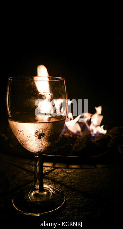 Verre de vin par l'incendie. soirée romantique. Banque D'Images