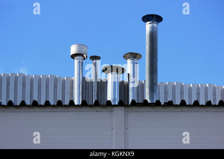 5 tuyau de cheminée en acier inoxydable sur le toit de la maison. Banque D'Images