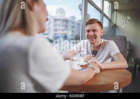 Smiling man sitting avec ma copine au restaurant Banque D'Images