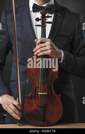 Au milieu du violoniste holding violin au tableau sur fond noir Banque D'Images