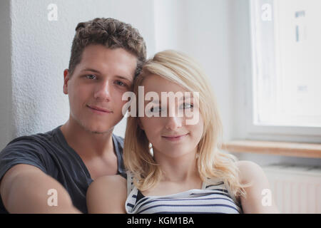 Portrait of young couple sitting at home Banque D'Images