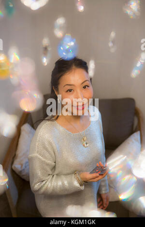 High angle portrait of smiling woman standing dans la salle de séjour à la maison Banque D'Images