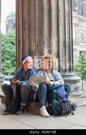 Smiling young'assis avec carte à l'Altes Museum, Berlin, Allemagne Banque D'Images