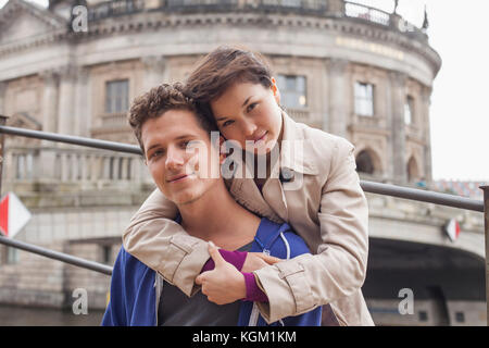 Low angle portrait of woman embracing ami masculin contre le Musée de Bode, Berlin, Allemagne Banque D'Images