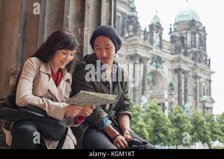 Low angle view of young amis lire la carte à l'Altes Museum, la cathédrale de Berlin, Allemagne contre Banque D'Images