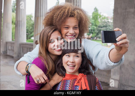 Jeune femme en tenant avec selfies female friends Banque D'Images