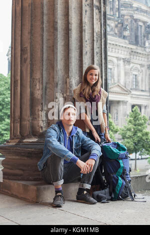 Portrait of smiling young friends par colonne à l'Altes Museum, Berlin, Allemagne Banque D'Images