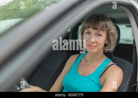 Portrait of smiling mature woman sitting in car Banque D'Images