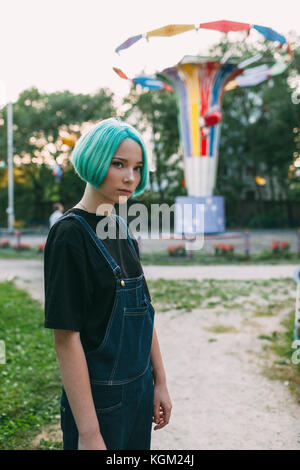 Portrait of teenage Girl standing against amusement park ride Banque D'Images