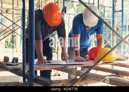 Concepts de construction, ingénieur et architecte working at construction site avec le plan directeur, effet vintage Banque D'Images