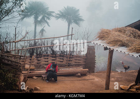 Ngai thau village, province de Lao Cai, Vietnam - 06 novembre 2015 : femme hmong assis devant sa maison de village, thau ngai province lao cao Banque D'Images