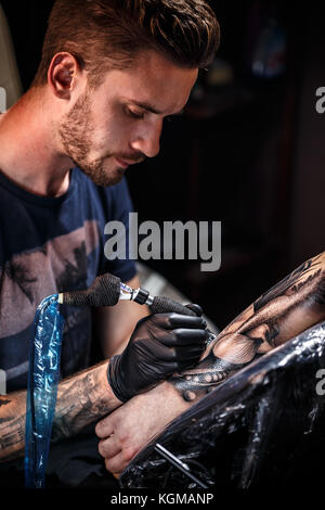 Artiste de tatouage tatouage au bras s'applique Banque D'Images