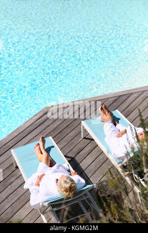 Senior couple relaxing by swimming pool en spa hotel Banque D'Images