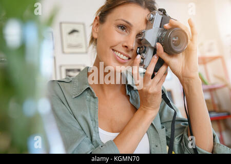 Portrait of Girl using camera in coffee shop Banque D'Images