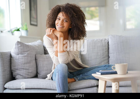 Beuatiful mixed race woman relaxing in canapé Banque D'Images